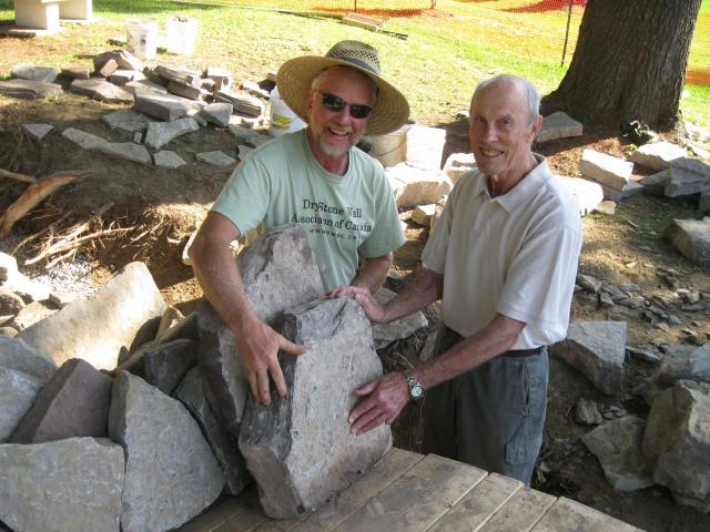 John and a local resident who remembers the old Macdougal Bridge being built, place a stone together